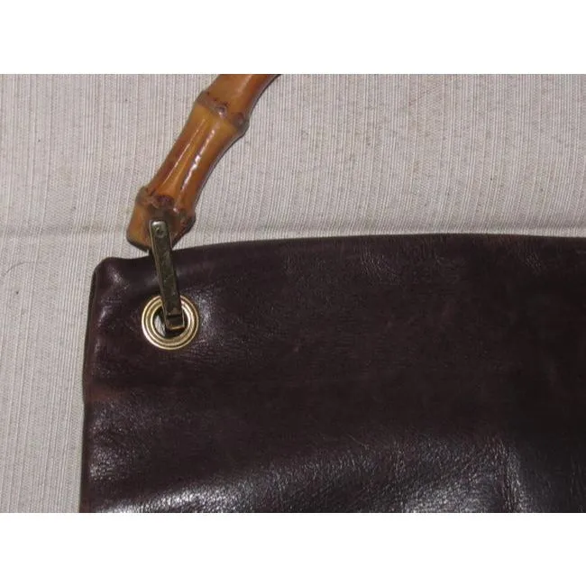 Gucci, mod look, supple brown leather satchel style bag with two bamboo handles & accents, gold tone hardware, a center zip closure